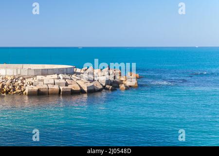 Coastal landscape with fishermen on breakwater in port of Alexandria, Egypt Stock Photo