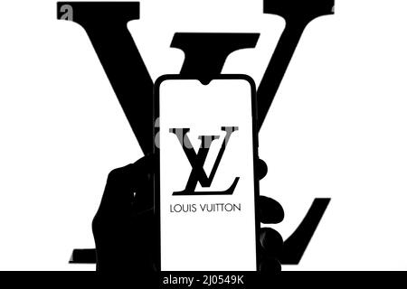 In this photo illustration a Louis Vuitton logo seen displayed on a  smartphone with a LVMH logo in the background Stock Photo - Alamy