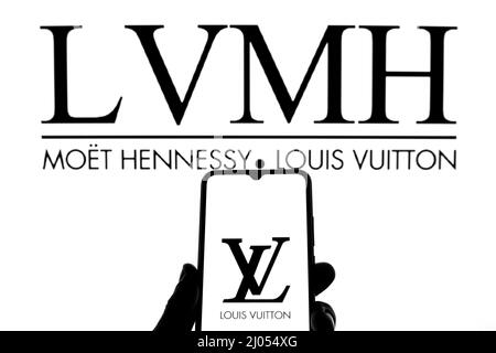 In this photo illustration a Louis Vuitton logo seen displayed on
