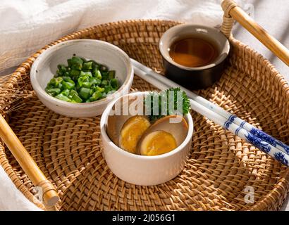 Traditional Indonesian food brineegg in a dish with spring onion, sauce and chopstick side view street food Stock Photo