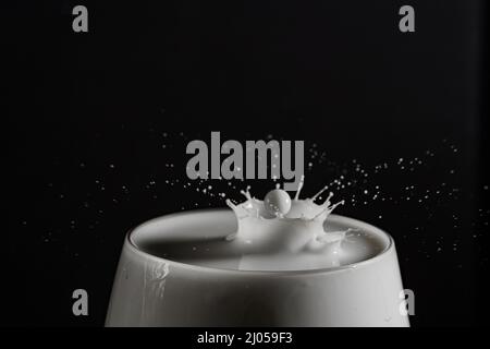 glass Milk or white liquid Splashes and drips isolated on a black background with copy space Stock Photo