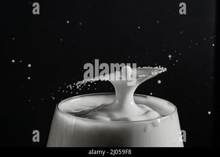 glass Milk or white liquid Splashes and drips isolated on a black background with copy space Stock Photo