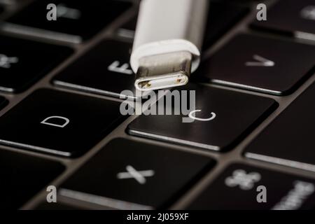 Close up of a usb cable with the Type-C connector located on the keyboard Stock Photo