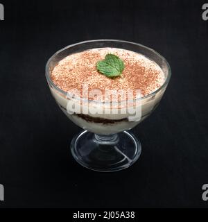 Tiramisu cream in a glass bowl isolated on black Stock Photo