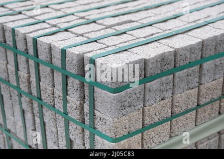 Paving stones on wooden pallet on the street sidewalk. Construction Paving of city streets and adjoining territories. Outdoor tile concrete paving blo Stock Photo