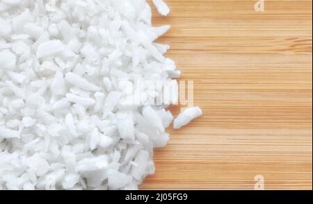 Close up picture of coconut shreds on a wooden background, selective focus. Stock Photo