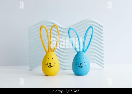 Blue and yellow Easter eggs with bunny faces, holiday decoration Stock Photo