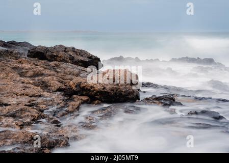 Waves break on the rock. Stock Photo