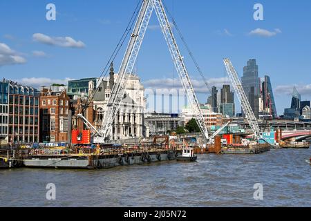 London, England - August 2021: Heavy mobile cranes on floating barges on the River Thames working on a large civil engineeering project Stock Photo