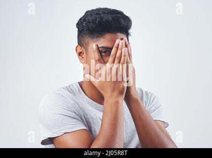 Lets go a bit deeper than appearance. Studio shot of a young man posing against a white background. Stock Photo