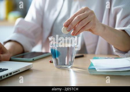 Unhealthy female taking painkiller from headache or migraine at workplace at home Stock Photo