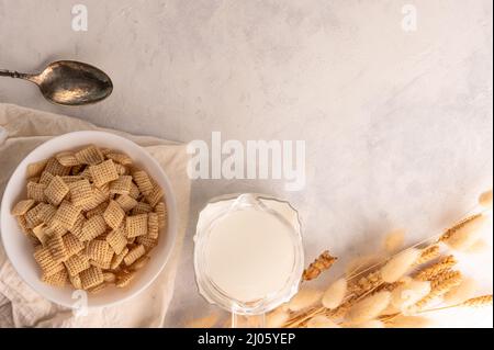 Whole grain pads, milk and a bunch of cereals on a white background. Low angle view. The concept is fast breakfasts, express food. Useful dietary prod Stock Photo