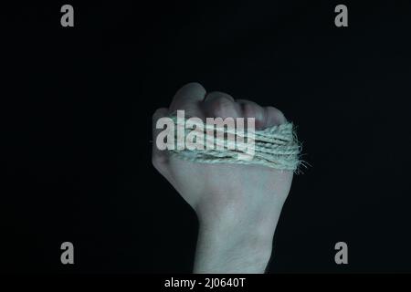 A piece of string tightly wrapped around a clenched fist Stock Photo