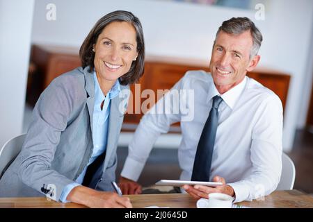 Theyre an experienced team. Shot of two mature business colleagues working together in the office. Stock Photo