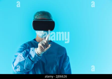 Professional doctor wearing virtual reality glasses focus on the foreground finger, isolated studio shot with blue background. High quality photo Stock Photo