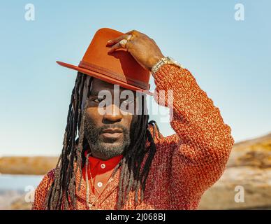Handsome attractive young african american man guy with dreadlocks and hat outdoor. Street photo. White Rock BC, Canada-March 3,2022 Stock Photo