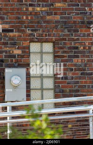 small window in old brick with modern rails Stock Photo