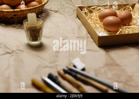 Tools for decorating Paschal eggs, Pysankas, with wax-resist dyeing technique. Collection of eggs. Homemade pen and melted beeswax for drawing of eggs Stock Photo