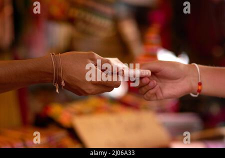 Goods for cash. Cropped shot of two hands exchanging cash at a store. Stock Photo