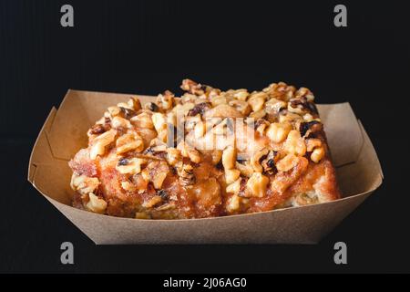 Walnut Frosted cinnamon roll close up on black background Stock Photo