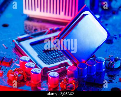 The desktop of the processor lies with the contacts up on the motherboard of a personal computer. macro photography. Blue neon lighting. Electronic an Stock Photo
