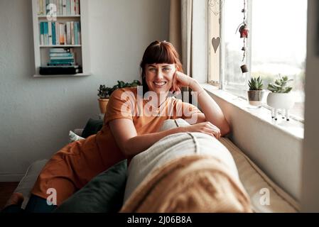 Sit back and relax because you deserve it. Shot of an attractive young woman relaxing on the sofa at home. Stock Photo