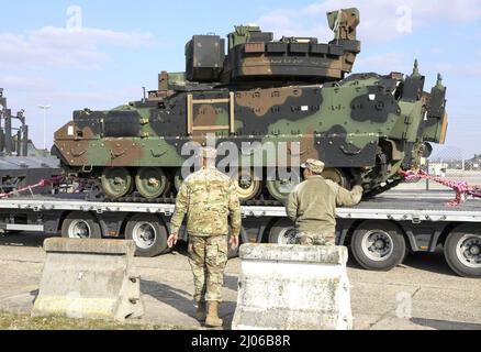 Bundeswehr Heavy Equipment Transport Systems (HETS) carrying American Bradley Fighting Vehicles (BFVs) are staged and inspected for onward movement at Coleman Barracks, Germany on March 7, 2022. The Bundeswehr work side‐by‐side with American partners to support the Army Prepositioned Stock program, help assure our Allies and deter Russian aggression. (U.S. Army photo by Staff Sgt. Jesse Pilgrim) Stock Photo