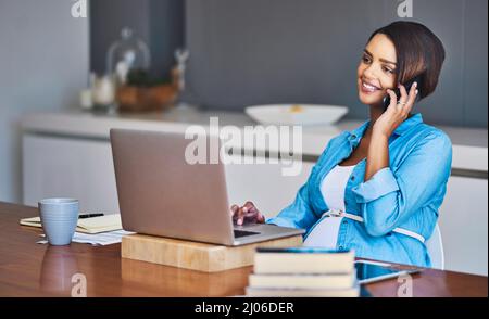 Growing a baby and a brand new business. Shot of a pregnant young woman using a laptop and mobile phone while working from home. Stock Photo