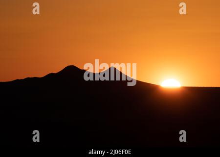 Tucson Arizona mountain silhouette with sun setting behind. Stock Photo