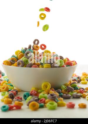Cereal crispy multi-colored rings in a bowl and near it on a white background. Close-up. Cereal fast breakfasts, nutrients, vitamins, healthy lifestyl Stock Photo