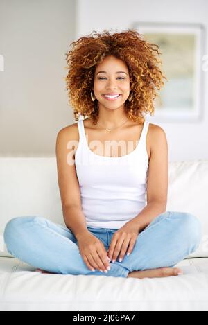 Theres something extremely exciting in owning a home. Shot of a young woman relaxing at home on the weekend. Stock Photo