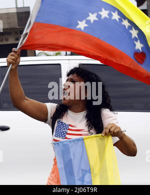 Valencia, Carabobo, Venezuela. 16th Mar, 2022. A woman wears a shirt with the flag of the United States while carrying the flags of Venezuela, Ukraine and Israel, as she shouts slogans for world peace and calls on passersby to condemn Russia's invasion and express solidarity with Ukraine. (Credit Image: © Juan Carlos Hernandez/ZUMA Press Wire) Stock Photo