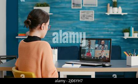 College student using laptop to attend remote videocall webinar with people and teacher. Woman meeting with colleagues on teleconference call at online school lesson, remote education. Stock Photo