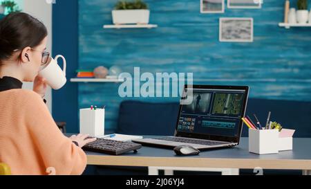 Content creator creating film montage with video editing software on laptop, working on online course assignment from home. Media designer developing movie making production on app. Stock Photo