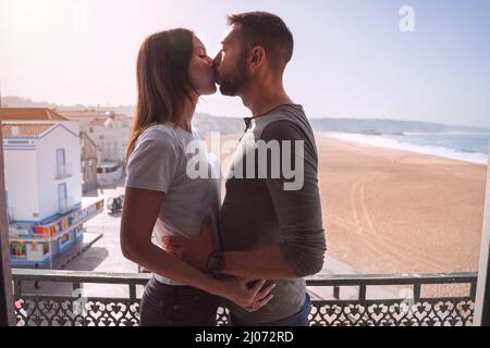 Young couple kissing on the balcony. Couple in love spending holiday together Stock Photo