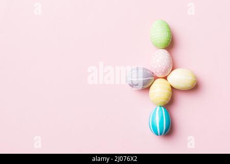 holiday preparation Multi colors Easter eggs on colored background, cross show the religious and secular side of Easter. Pastel color Easter eggs. hol Stock Photo