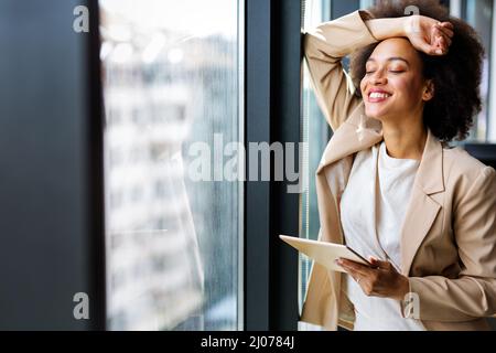 Portrait of a smiling confident african american young businesswoman working with digital tablet Stock Photo