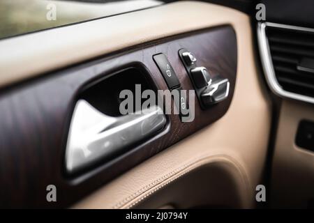 Car door handle and lock switch inside luxury and modern vehicle with leather interior, design background Stock Photo