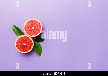 fresh Fruit grapefruit with Juicy grapefruit slices on colored background. Top view. Copy Space. creative summer concept. Half of citrus in minimal fl Stock Photo
