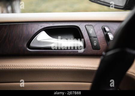 Car door handle with door lock control panel inside the luxury car interior with leather Stock Photo