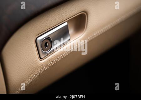 Closed with key glove compartment box in luxury car with leather, close-up interior background photo Stock Photo