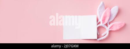 Easter banner in pink with Easter greeting card mockup and decorative bunny ears. Stock Photo