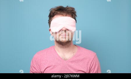 Ready to sleep. Caucasian man wearing a sleeping mask while being ready to sleep Stock Photo