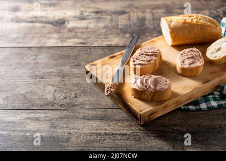 Toasted bread with pork liver pate on wooden table Stock Photo