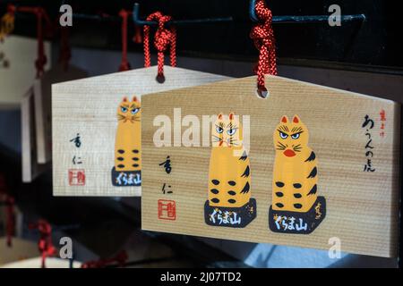 Japanese wooden prayer boards or Ema 絵馬 hanging at a temple in Kyoto, Japan, showing Japanese writing Stock Photo