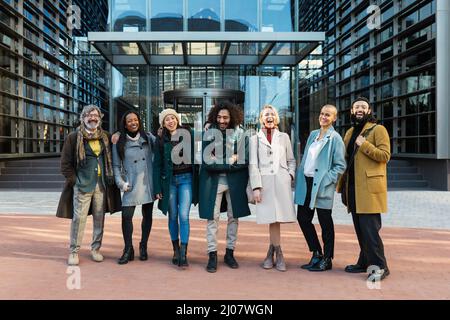 Professional business people laughing and having fun while standing together outside office building. Stock Photo
