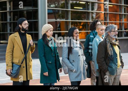 Group of serious businessmen and women standing looking forward Stock Photo