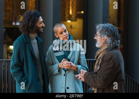 Group of professional business people talking while standing outdoors on the street. Stock Photo