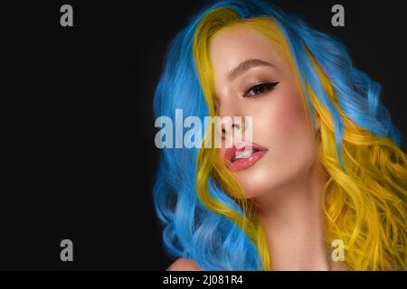 Beautiful woman with blue and yellow hair and classic make up and hairstyle. Beauty face. Stock Photo