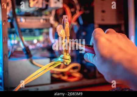 Cutting the Internet cable tied into a knot with wire cutters. The concept of disconnecting the Internet and restricting access to resources Stock Photo